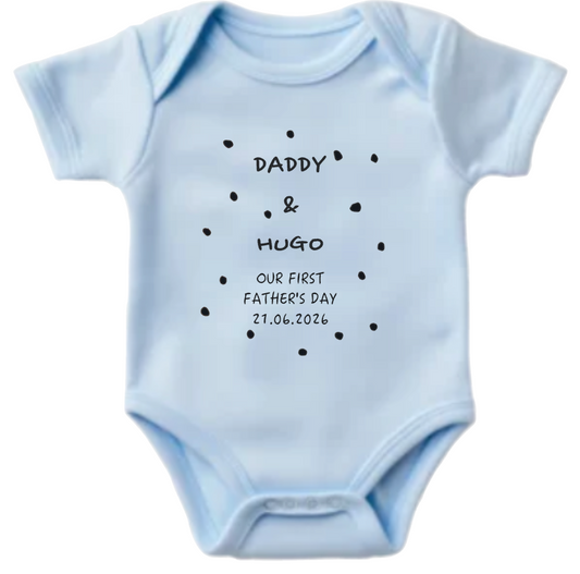 Light blue baby onesie with text and polka dots on a white background